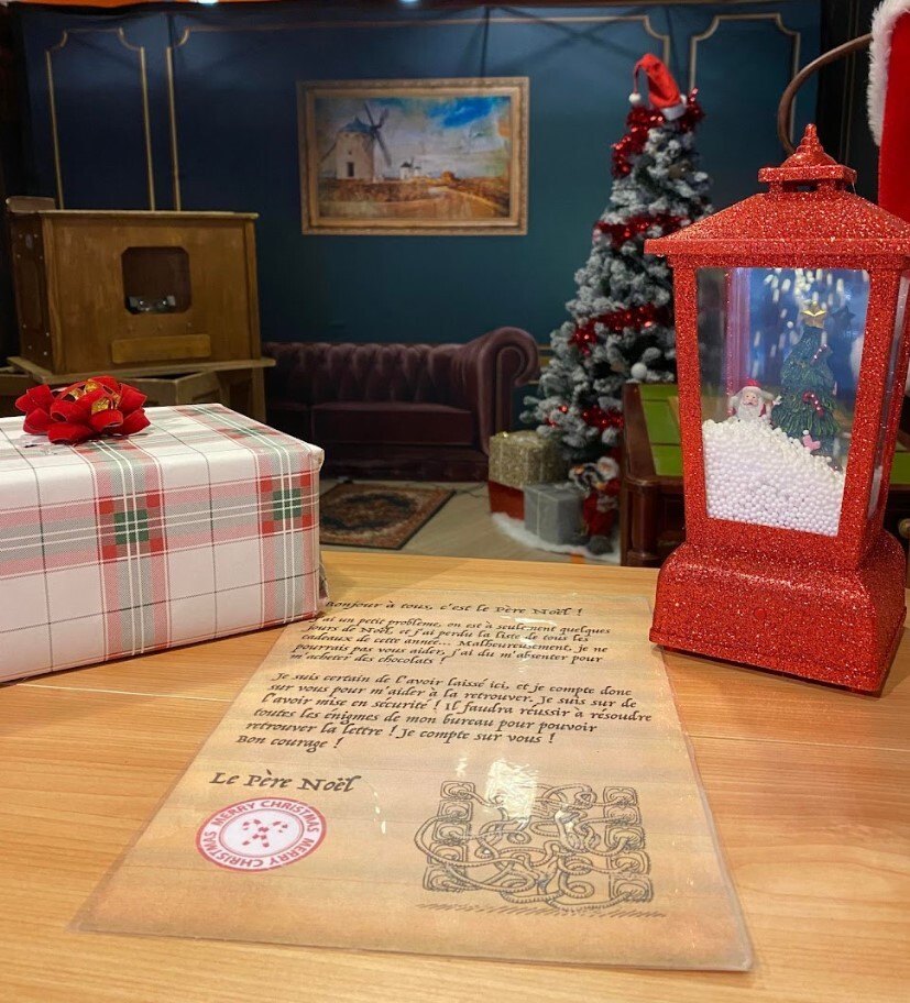 Décor de l'escape game mobile L'Atelier du Père Noël avec sapin et paquets cadeaux