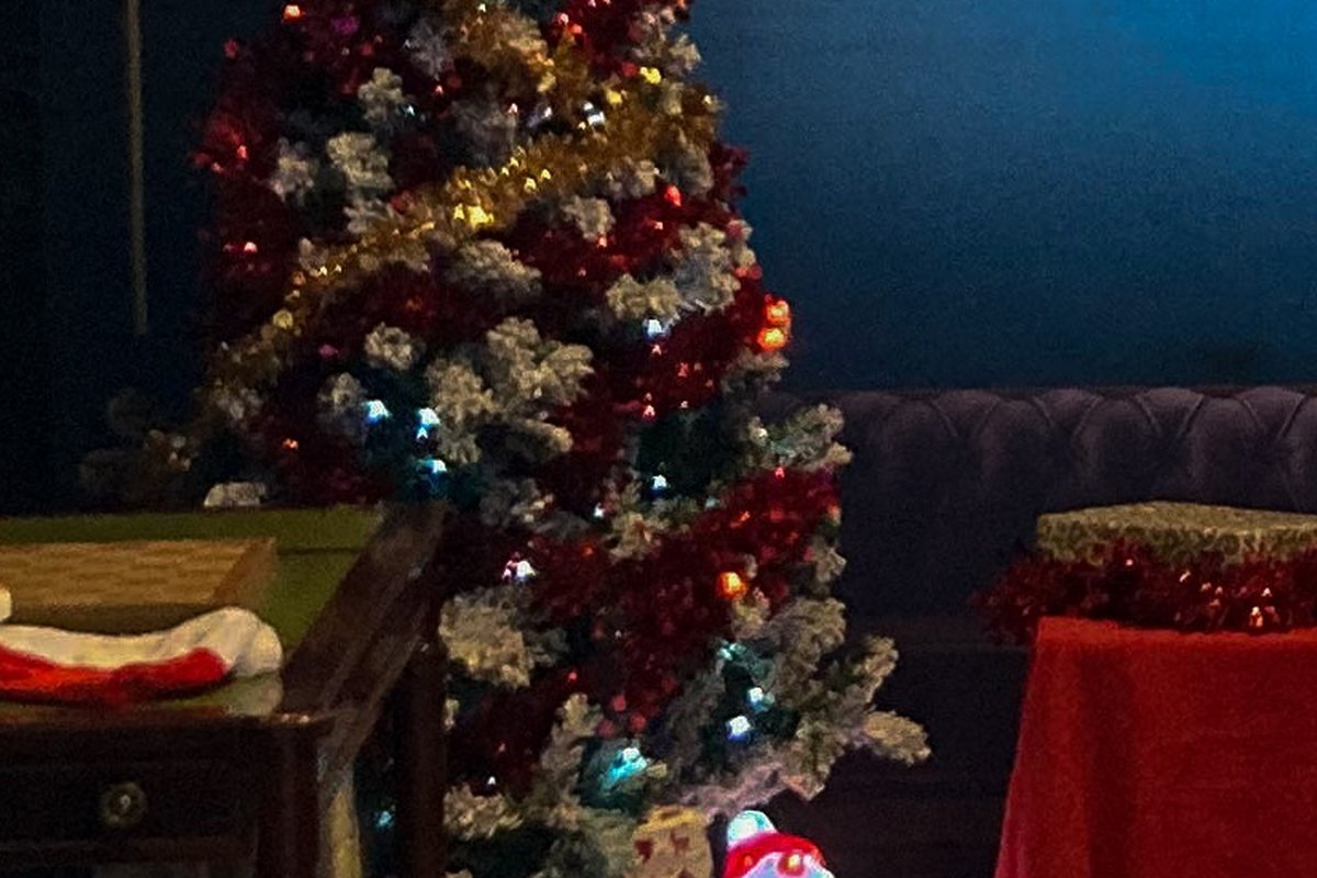 Sapin givré rouge et argent et paquets cadeaux dans le décor d'escape game de l'Atelier du Père Noël