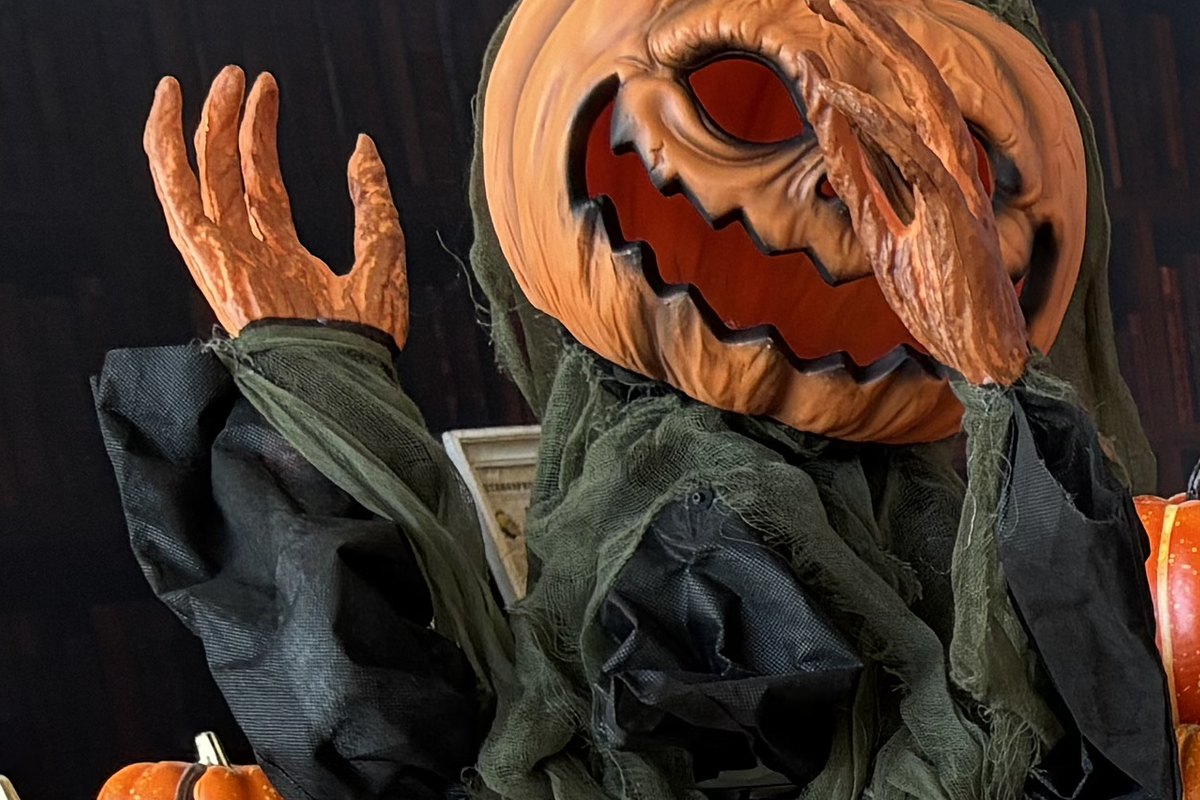 Le Repère de la Sorcière, escape game mobile pour Halloween en famille, épouvantail à tête de citrouille et petites citrouilles posées au sol