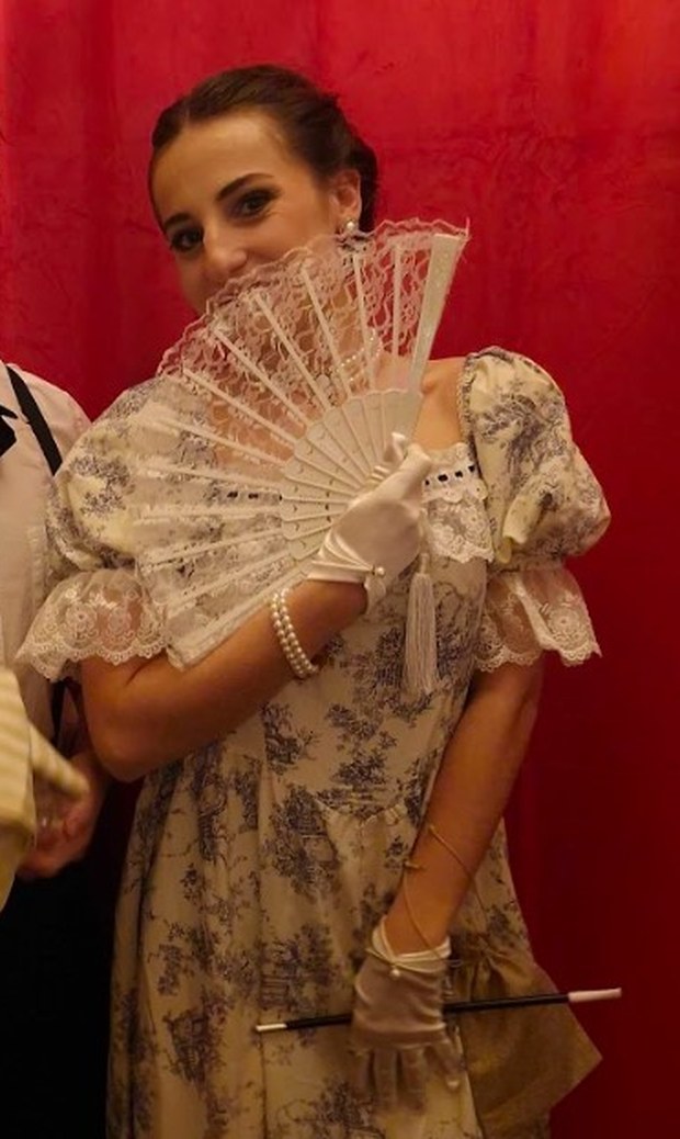 La Débutante, une des convives suspectes du gala, robe fleurie et éventail de dentelle