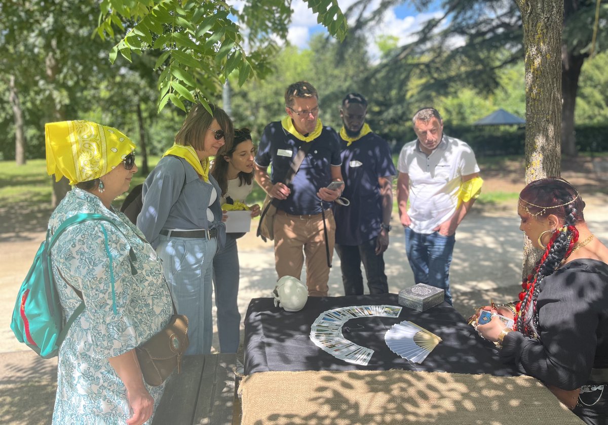 Groupe de participants autour de la table de tarot de la Voyante, en extérieur