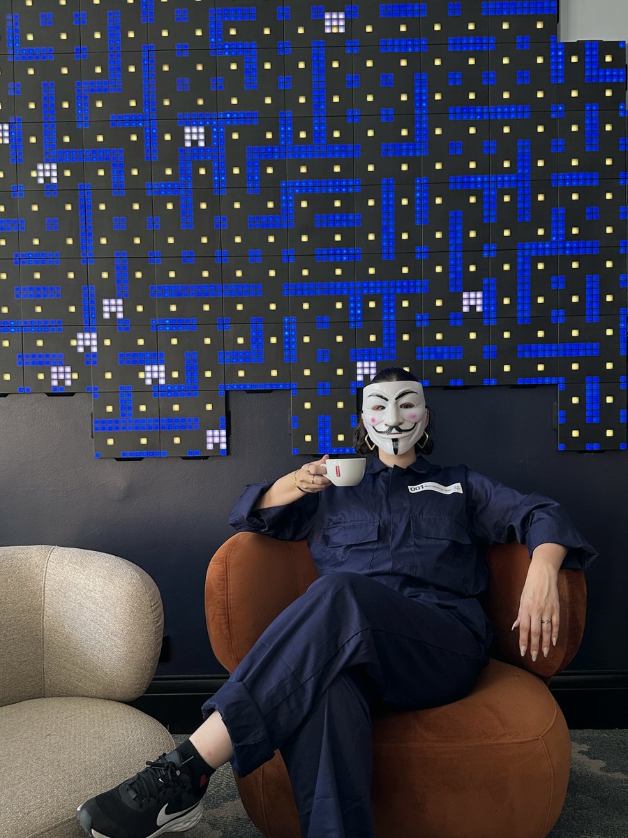 Joueuse masquée devant un mur lumineux de données clignotantes
